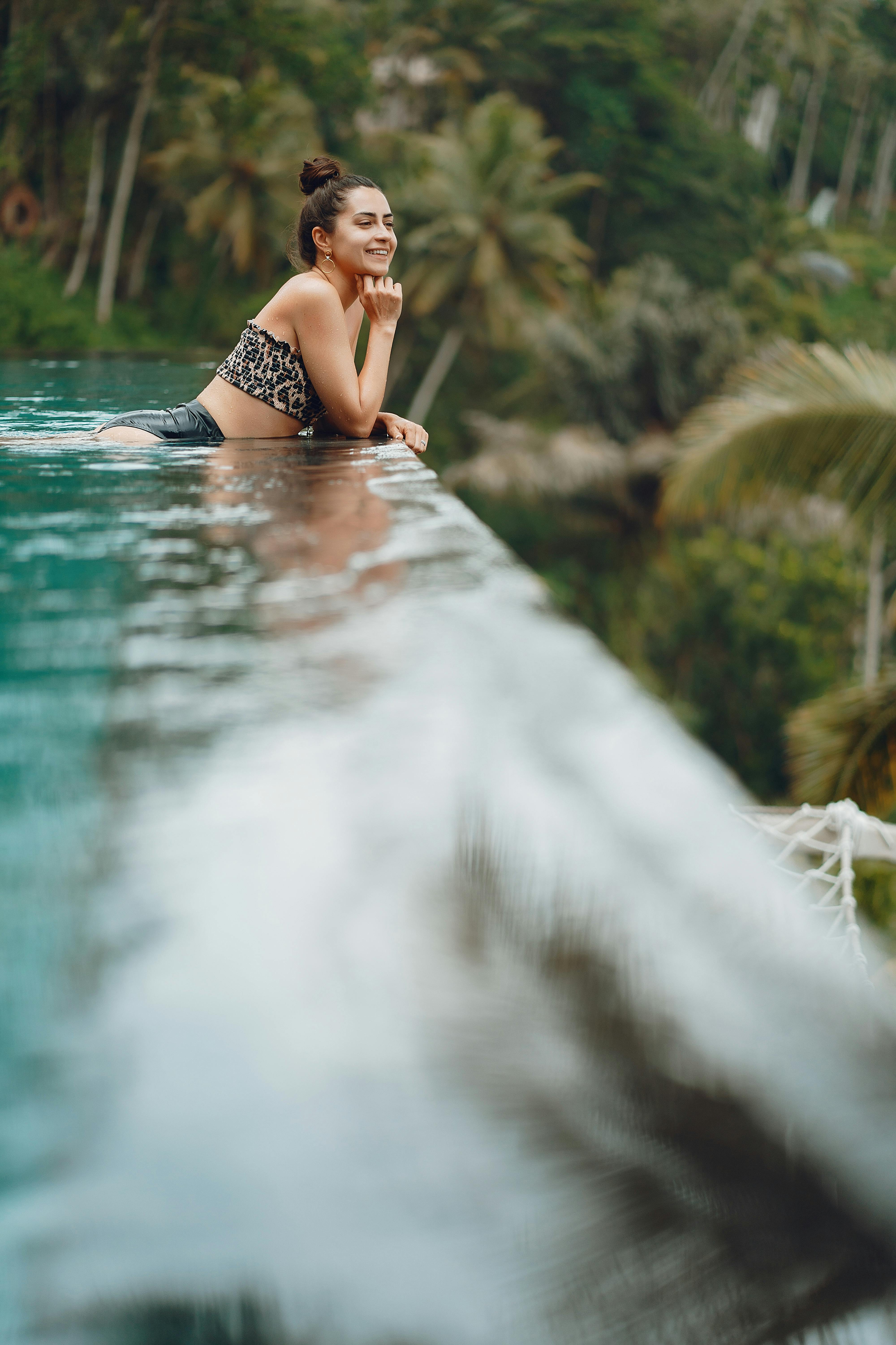 Happy woman resting in pool in tropical resort · Free Stock Photo