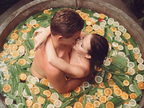 Sensual couple hugging and kissing in stone fruit bath