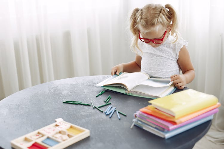 Focused Girl Reading Book At Home