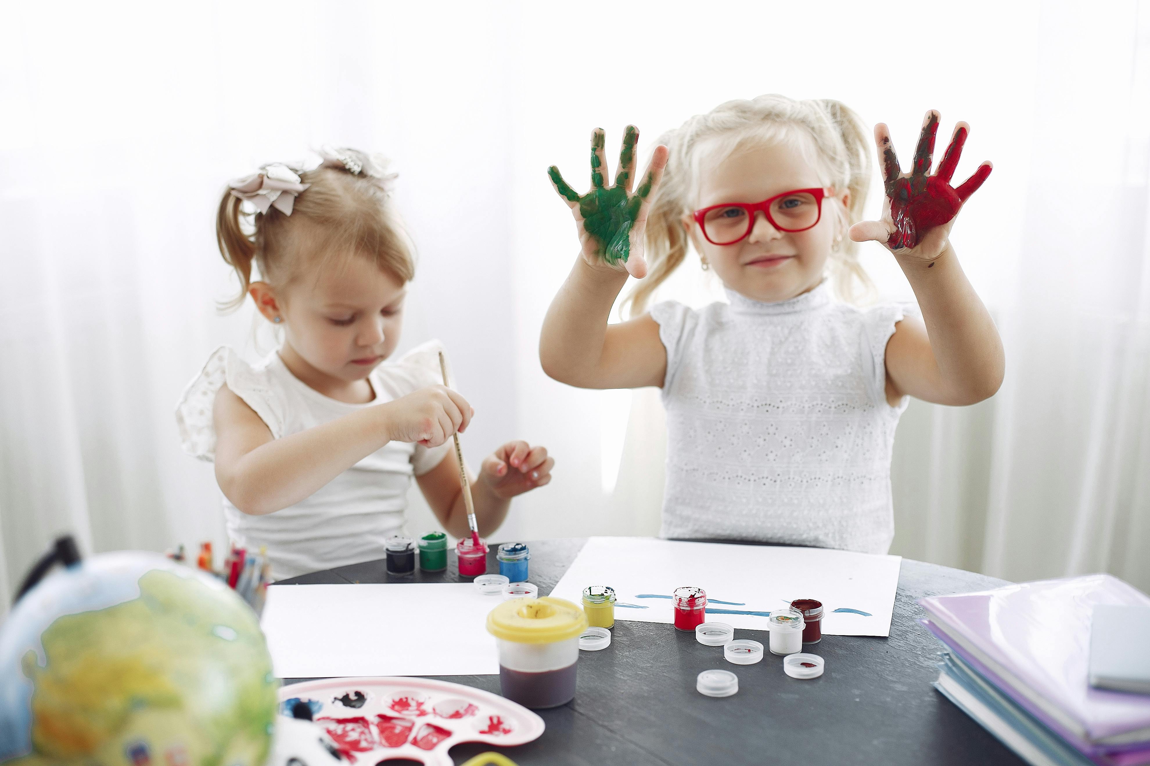 children playing with paint in kindergarten