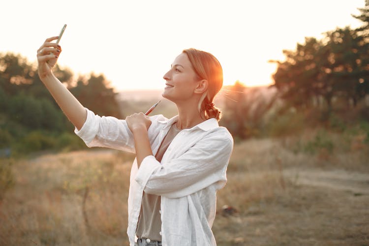 Happy Woman Taking Selfie In Nature