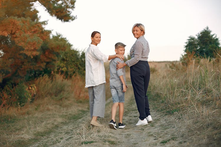 Happy Multi Generational Women With Kid Walking In Nature