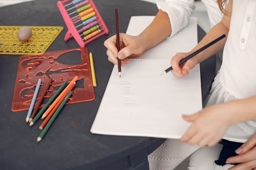 Free Crop schoolchild learning to count at home with tutor Stock Photo