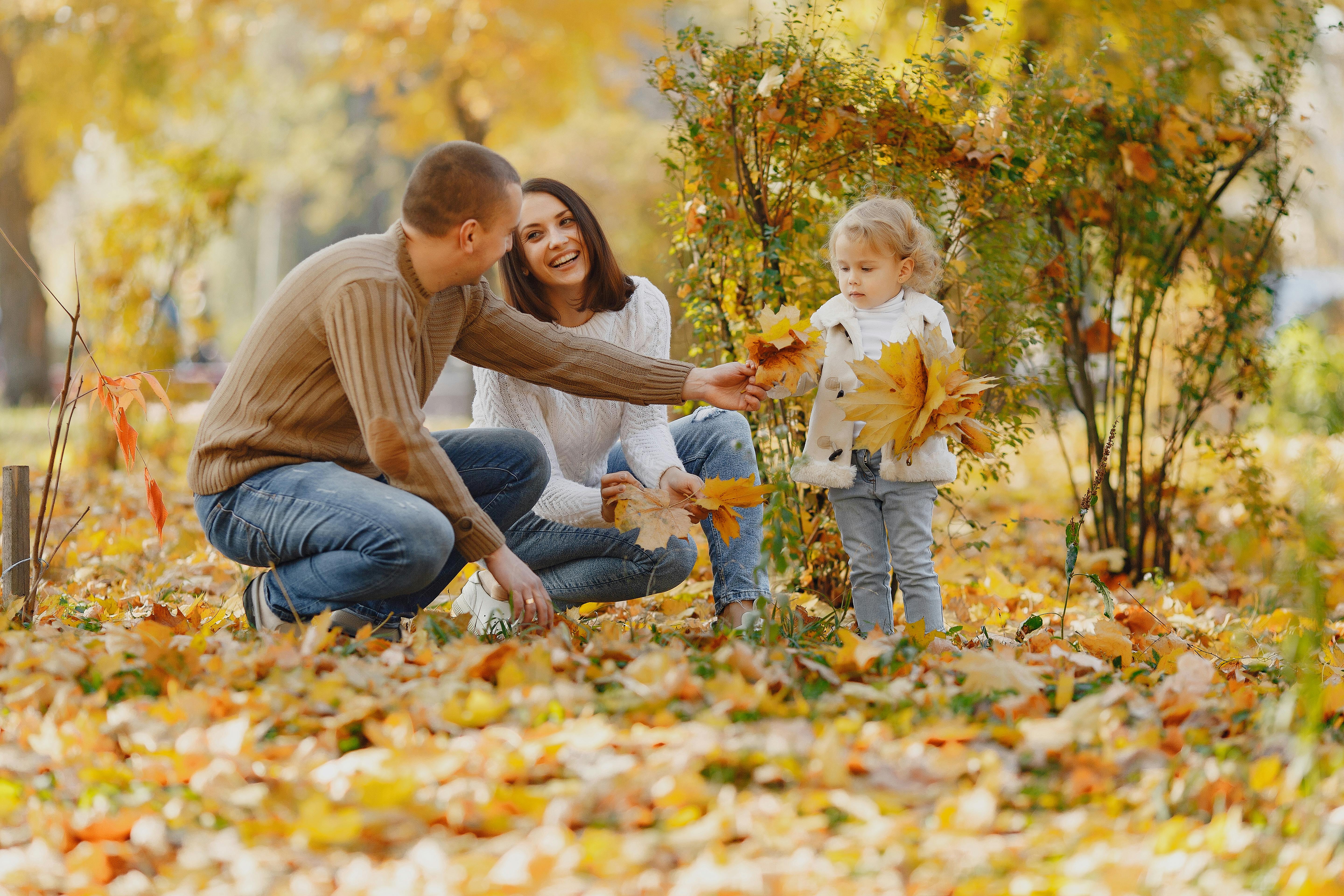 happy family with little daughter in autumn park