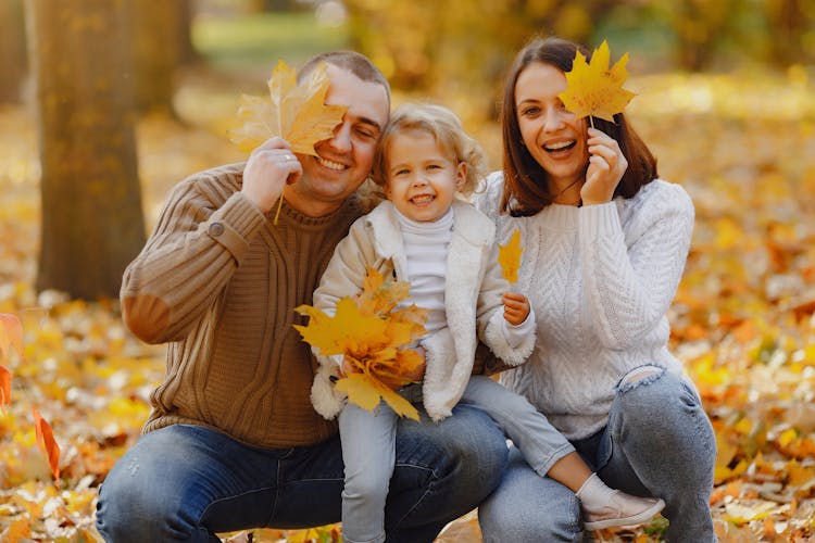 Cheerful Family Having Fun With Autumn Leaves