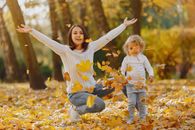 Playful mother and daughter having fun in autumn park