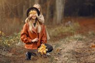 Happy mother and daughter playing in autumn forest