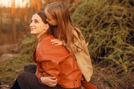 Tender woman with girl resting in autumn park