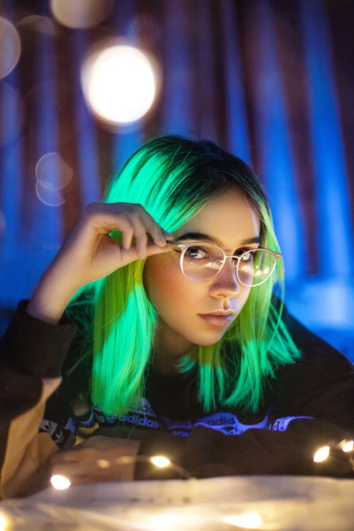 A Woman With Neon Green Hair Wearing Eyeglasses