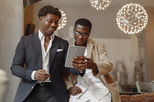 Happy businessmen browsing tablet in modern workspace