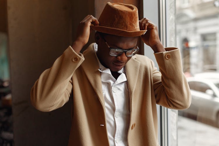 Confident Man Putting On Stylish Hat