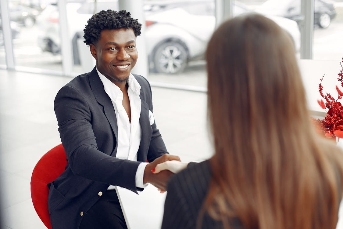 Car buyer shaking hands with agent
