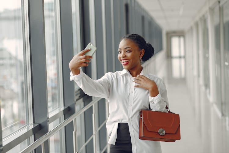 Joyful Woman Taking Selfie In Modern Building