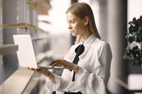 Focused worker using laptop in office lobby