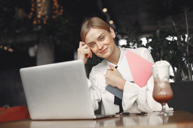 Positive Businesswoman Working On Laptop In Restaurant