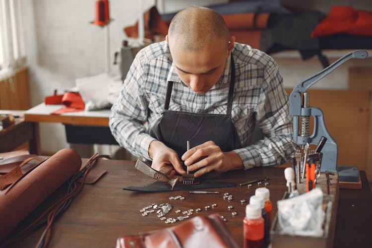 Artisan Attaching Metal Snaps On Leather