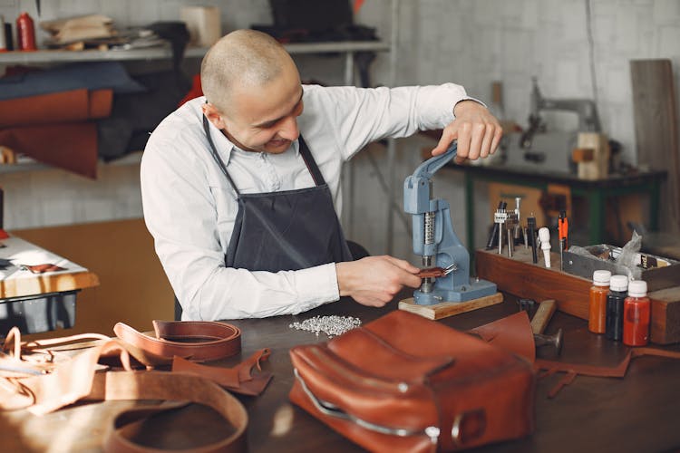 Cheerful Craftsman Attaching Metal Snaps On Leather Strip