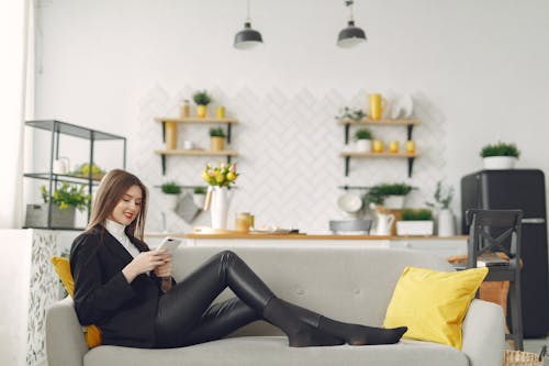 Young woman messaging on smartphone in living room