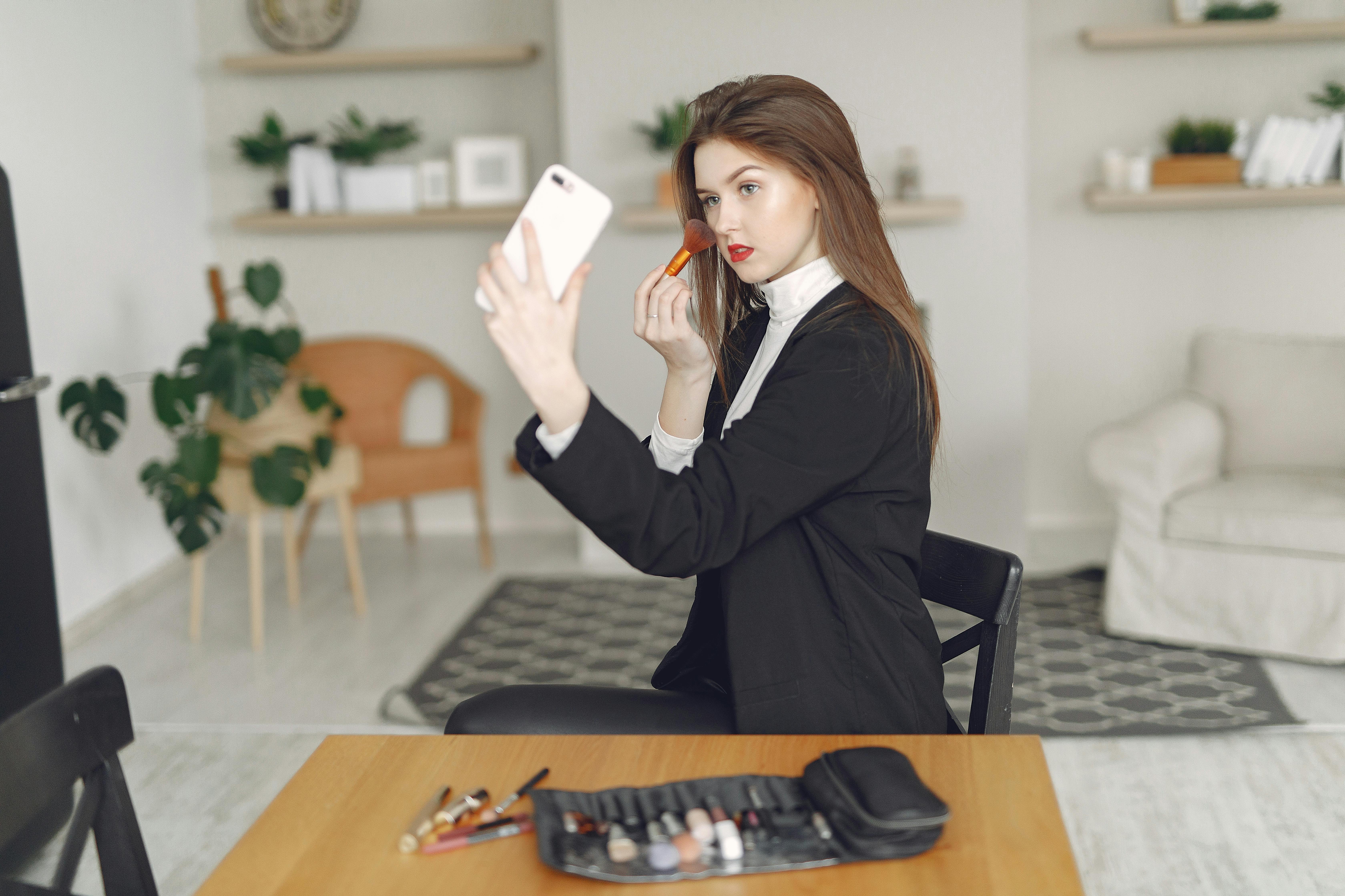 young female blogger recording video on smartphone at home