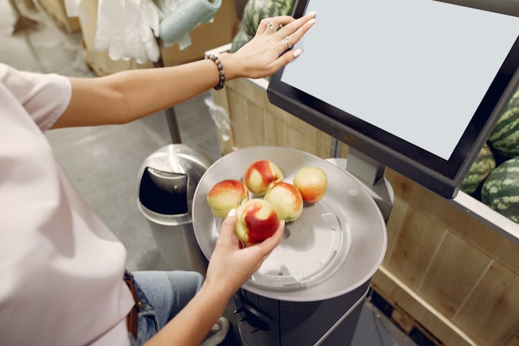 Crop Woman Weighing Peaches On Scales In Grocery Store