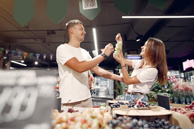 Smiling Couple Buying Fruits In Grocery Store