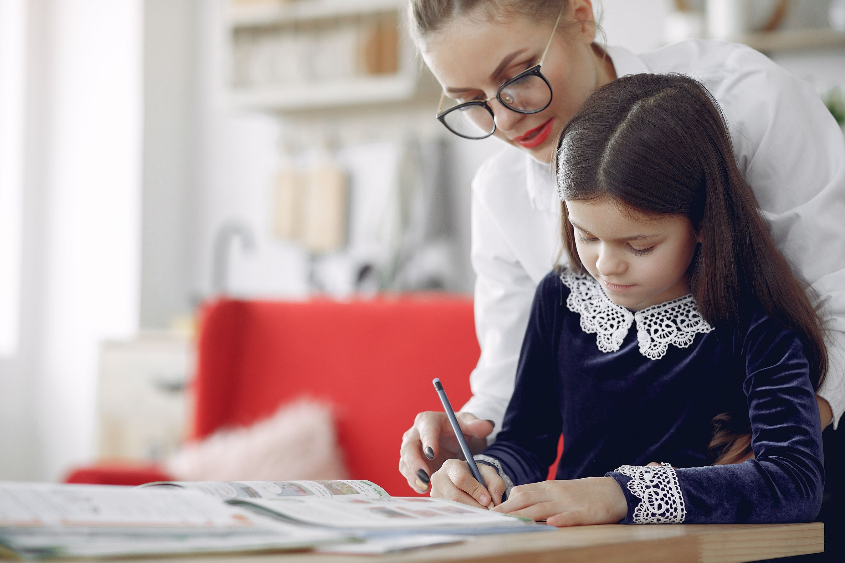Personalised 1:1 home tutor warmly guiding a young student during a bright in-home learning session