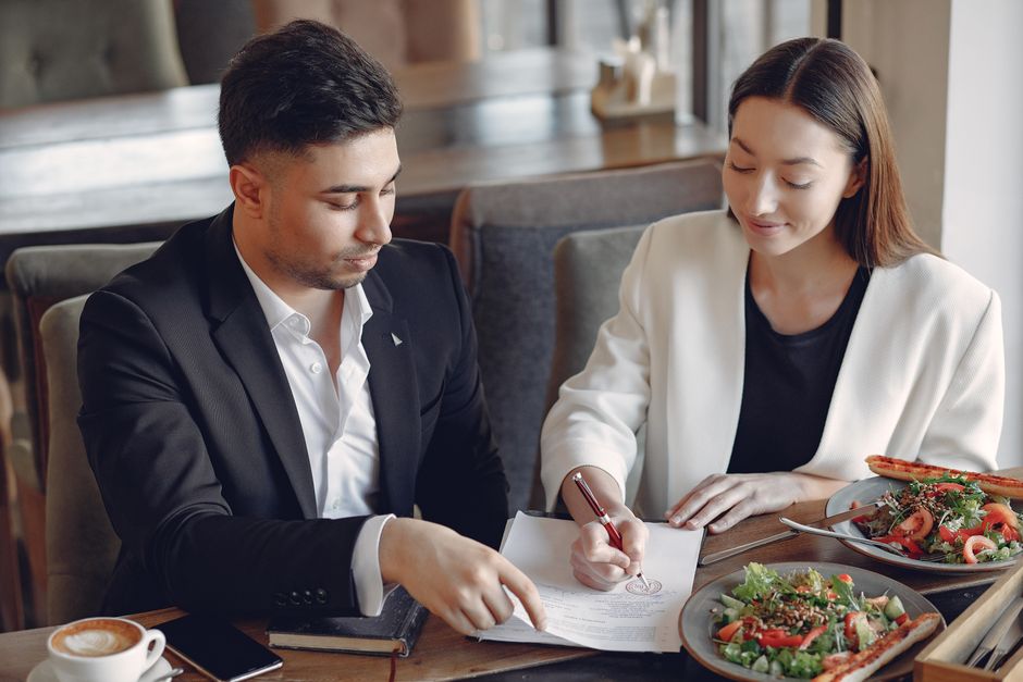 A professional business lunch setting with people talking over plates - almoço in english A professional business lunch setting with people talking over plates - almoço in english