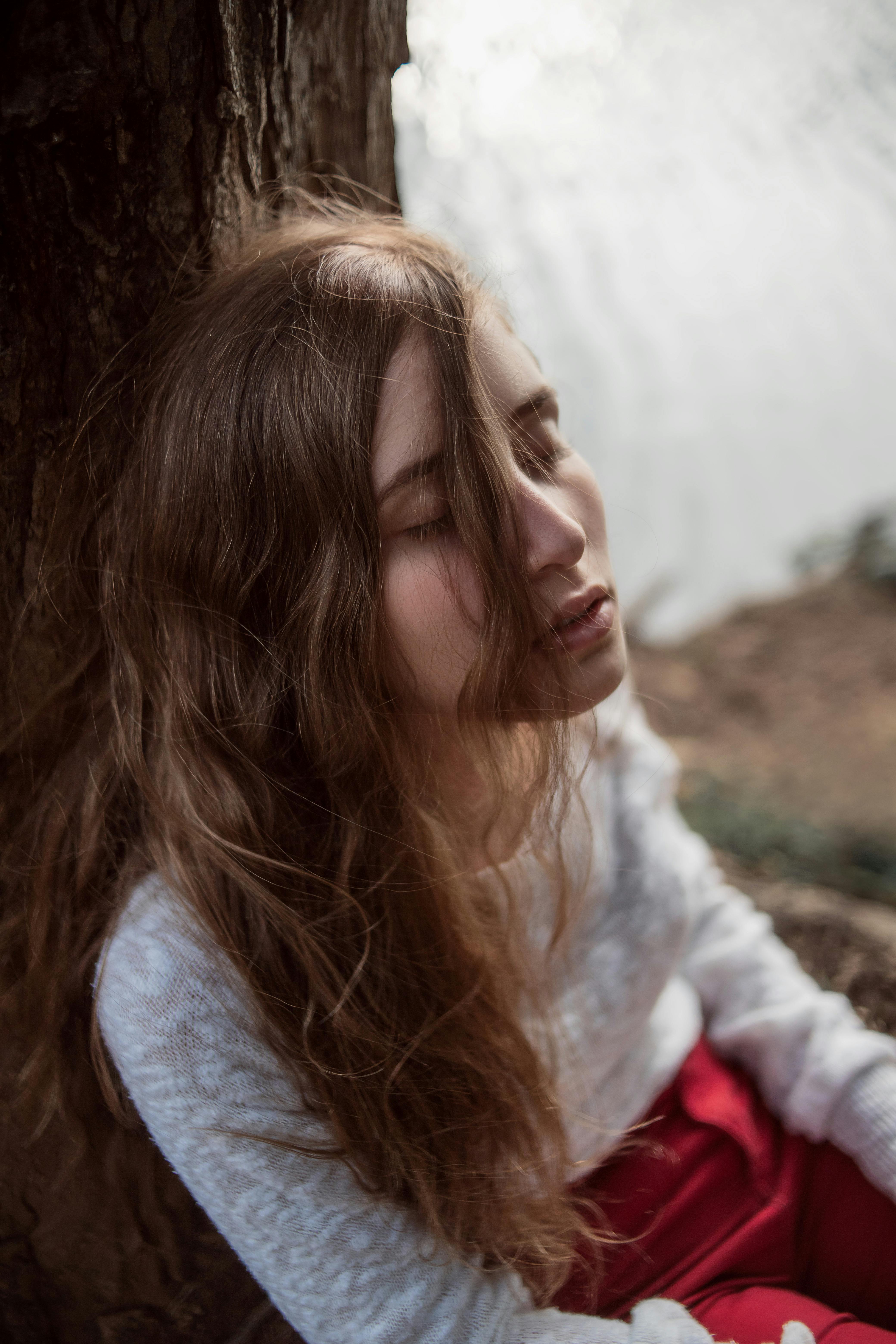 在巴西贝洛奥里藏特，一名年轻女子闭着眼睛，在宁静的湖边放松身心