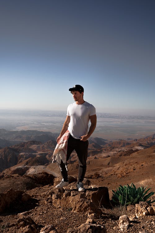 A Man in White Crew Neck T-shirt Standing on the Mountain