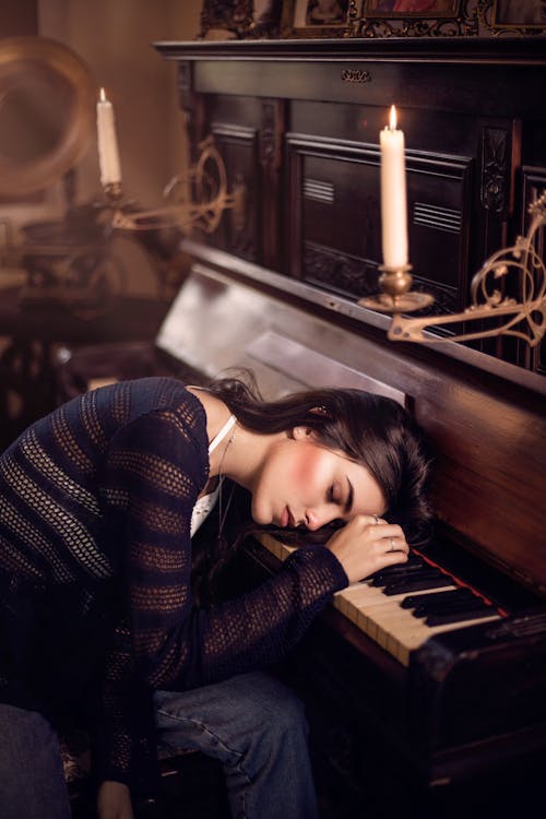 Femme En Pull Noir Et Blanc Allongé Sur Piano
