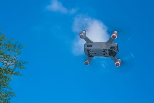 From below of bottom half of quadcopter with lightning motors and spinning propellers