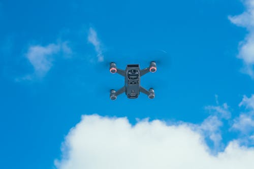 Modern UAV against blue sky with clouds