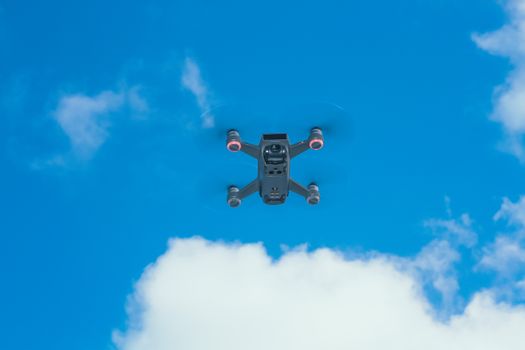 From below of small remote control aircraft with photo camera and spinning propellers