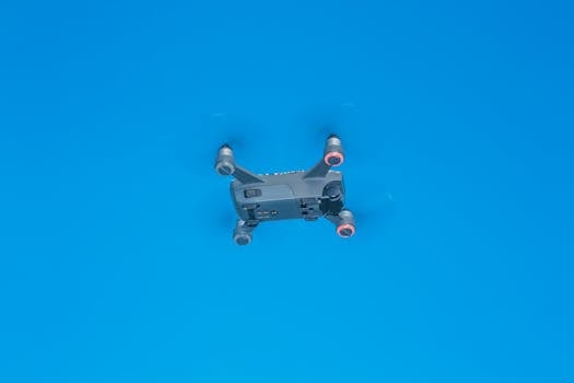 From below of side part of remote control drone with quickly spinning propellers and small cameras for taking photos and videos