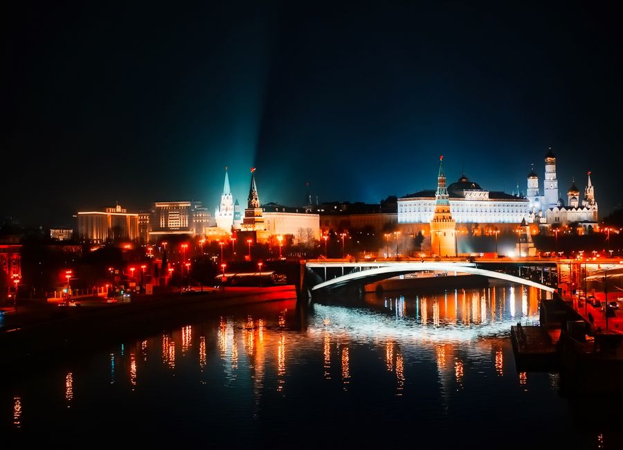 Stunning night view of Moscow's illuminated skyline with reflections on the river.