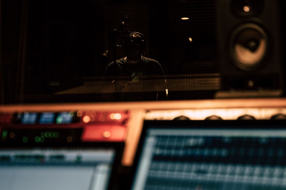 Singer wearing headphones in a dark recording studio, photo by Brett Sayles on Pexels