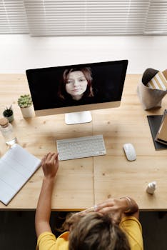 A high-angle shot of a woman having a video call at home, showcasing remote work setup.