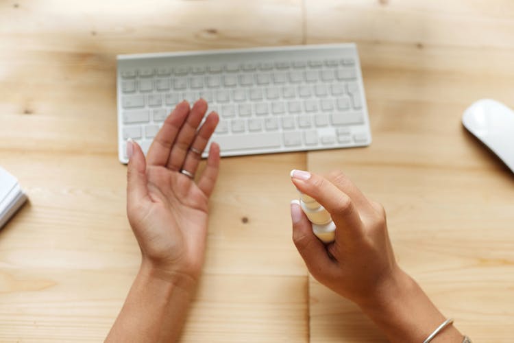 Person Spraying Sanitizer On Hands