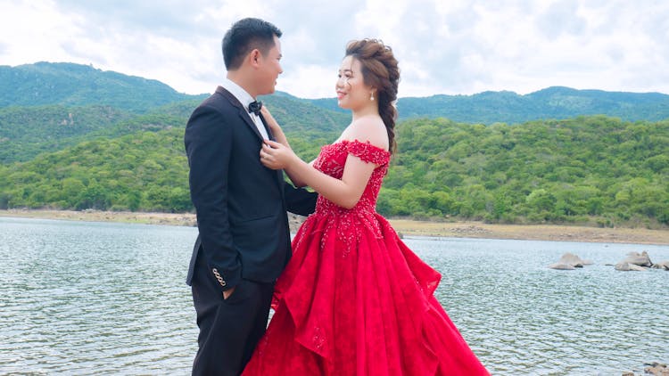 Elegant Asian Couple Embracing Near Lake On Wedding Day