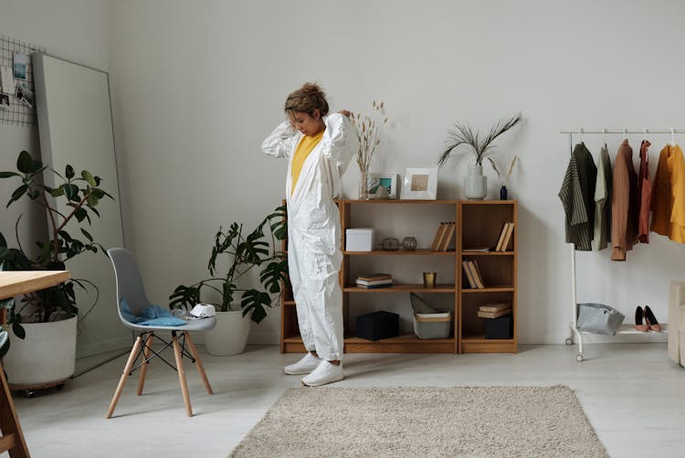 Woman Putting On A White Hazmat Suit