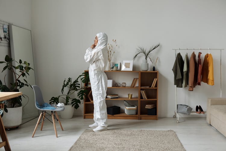 Woman Putting On A White Hazmat Suit