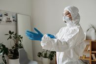 一名医护人员在室内穿着全套个人防护装备，包括口罩和手套
