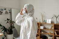 医护人员在房间内穿着全套防护装备，包括口罩、护目镜和防护服