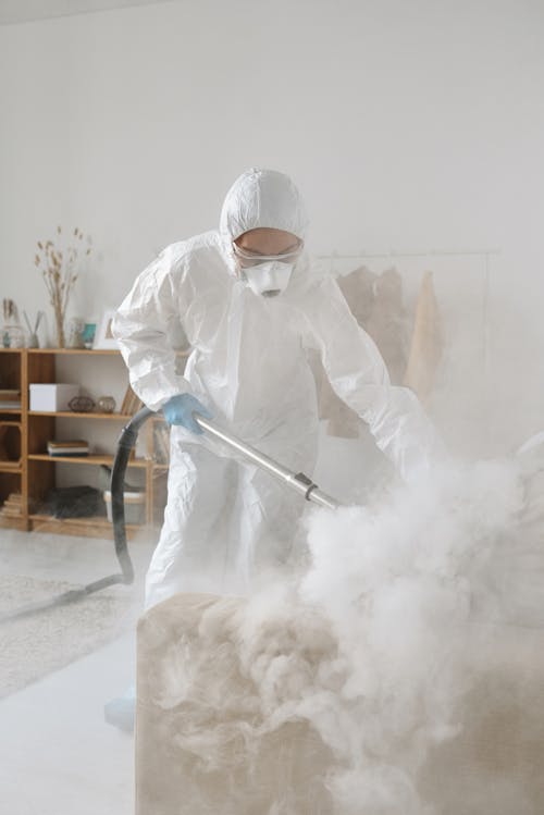 A Woman in a Protective Suit Fumigating 