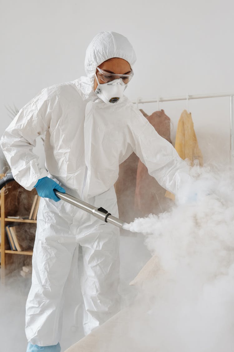 A Woman In PPE Disinfecting 