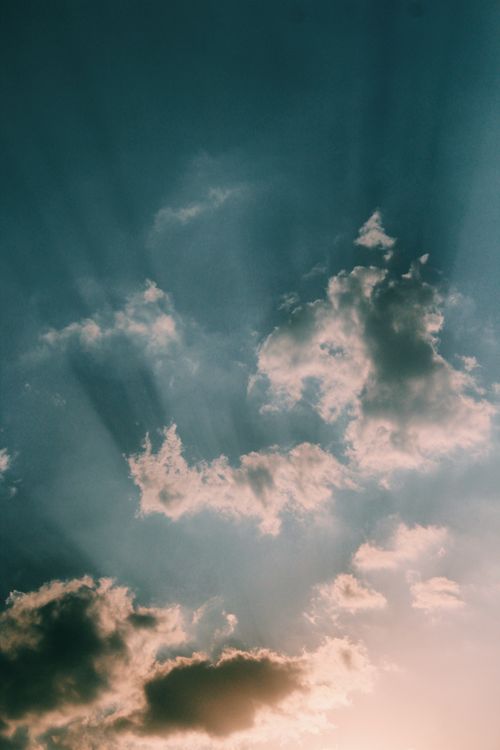 Free Dramatic sky capturing sun rays bursting through clouds at dawn. Perfect for nature backdrops. Stock Photo