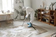 A Woman Fumigating a Carpet