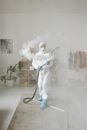 A Woman in PPE Fumigating