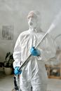 A Woman Wearing a Protective Suit While Fumigating