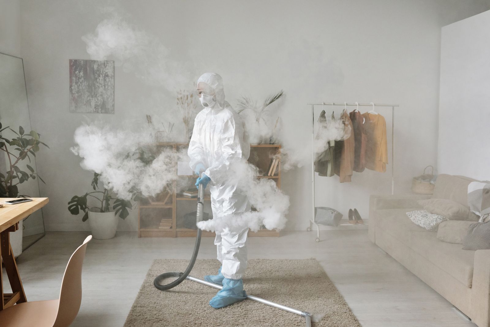 Technician in protective equipment carrying out specialist indoor remediation